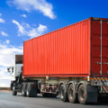 How are shipping containers transported by truck?